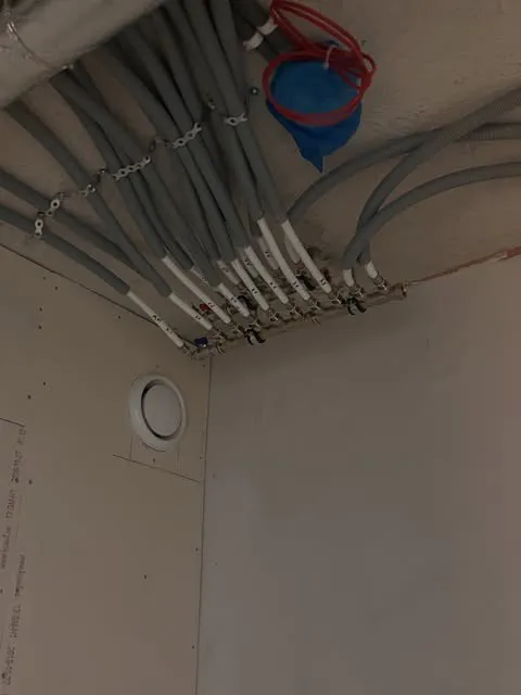 Fördelare för tappvatten i taket med många grå rör som löper ut i rummet